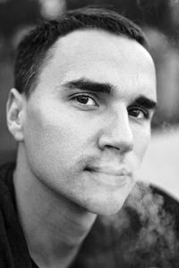 Close-up portrait of young man exhaling smoke