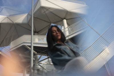 Low angle view of woman standing against clear sky