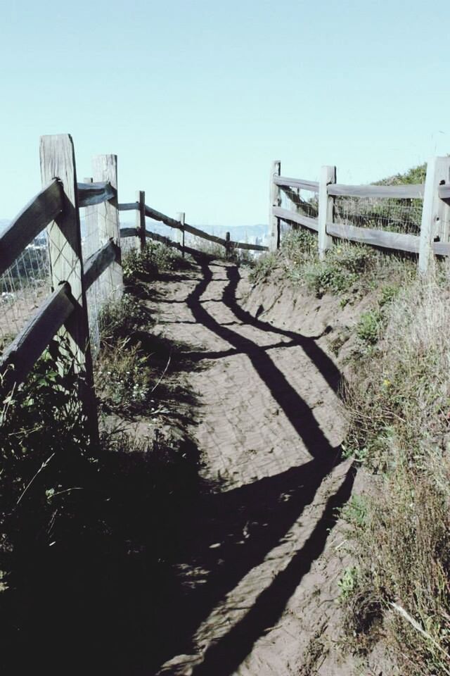 clear sky, shadow, sunlight, railing, full length, walking, lifestyles, leisure activity, rear view, built structure, fence, men, day, copy space, standing, steps, outdoors, architecture