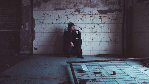 Rear view of woman standing against wall