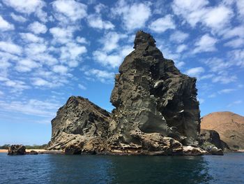 Low angle view of rock formation by sea against sky