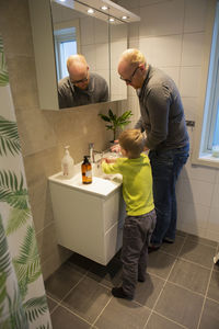 Father and son washing hands in bathroom