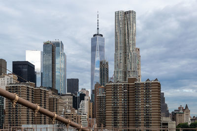 Modern buildings in city against cloudy sky