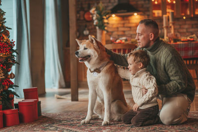 Candid authentic happy family during wintertime together enjoying holidays with dog at xmas