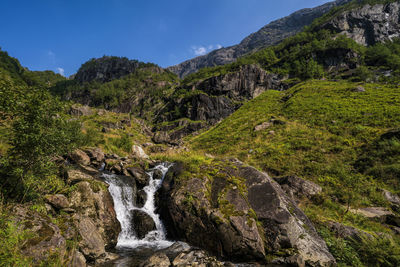 Scenic view of waterfall against sky