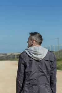 Man standing on field against clear sky