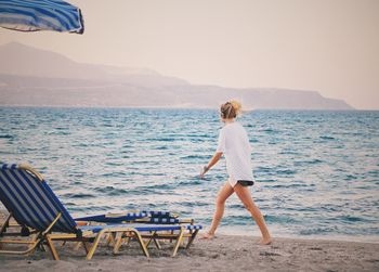 Rear view of woman looking at sea against sky