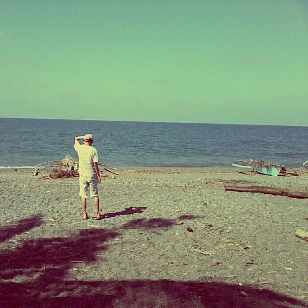 sea, beach, horizon over water, water, shore, sand, clear sky, leisure activity, copy space, lifestyles, vacations, tranquility, tranquil scene, beauty in nature, scenics, full length, person, nature, rear view