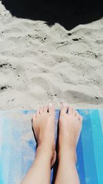 Low section of woman relaxing on beach