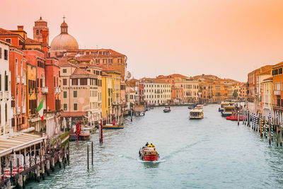 Boats in canal amidst buildings in city