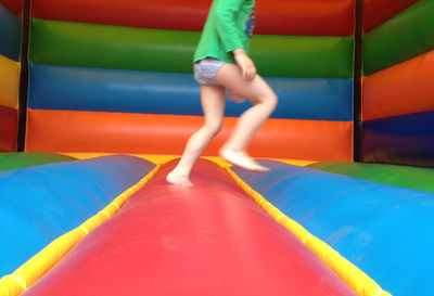 Low section of playful boy in inflatable bouncer