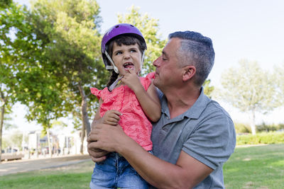 Father and daughter spending time together outdoors in a park.