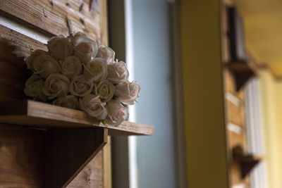 Close-up of roses on wooden shelf