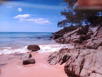 Scenic view of rocks on beach against sky