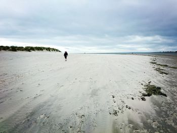 Man and woman standing on sandy beach