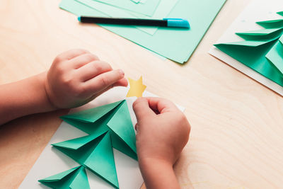 High angle view of baby hand holding paper