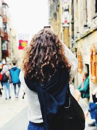 Rear view of woman walking on street in city