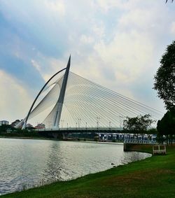 Bridge over river against cloudy sky