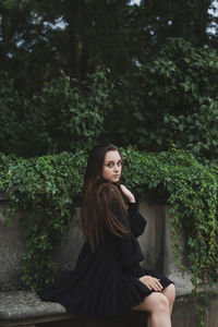 Portrait of beautiful young woman sitting in park