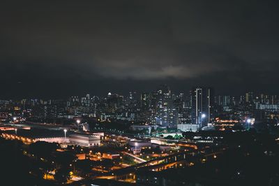 Illuminated cityscape against sky at night