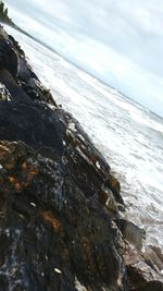 Close-up of waves on beach against sky