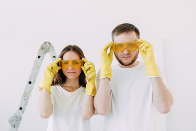 Happy smiling married couple engaged in renovation repair in the room of the house preparing to move