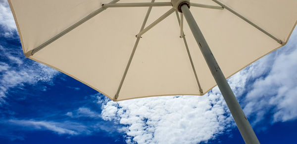 Low angle view of sunshade against sky