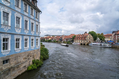 River amidst buildings in city against sky