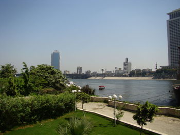 Scenic view of sea and buildings against clear sky