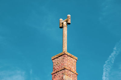 Low angle view of cross on building against sky