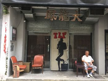 Man sitting on chair outside building