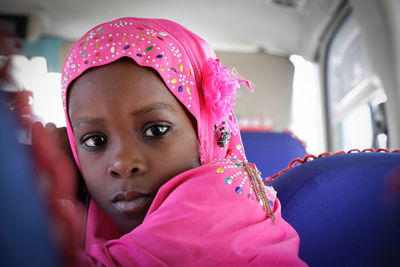 Portrait of girl wearing pink hijab in bus