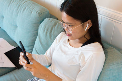 Asian teenage girl lay down using mobile phone