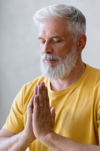 Mature man meditating at home