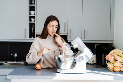 Young woman eating food at home