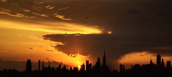 Silhouette buildings against sky during sunset