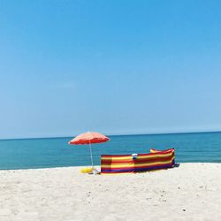 Beach against clear blue sky