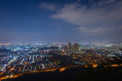 High angle view of illuminated cityscape against sky at night