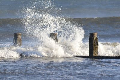 Waves splashing in sea against sky