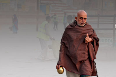 Man looking at camera while standing in city