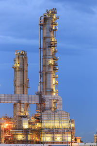 Low angle view of illuminated factory against sky