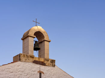 Bell tower against clear blue sky
