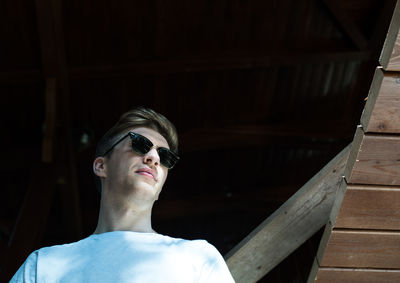 Low angle view of young man wearing sunglasses in hut