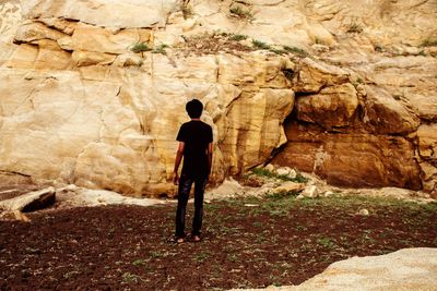 Rear view of man standing on rock