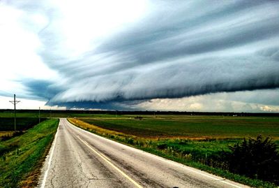 Country road against cloudy sky