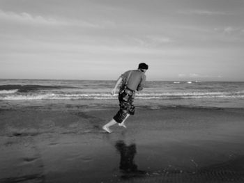 Full length of man on beach against sky