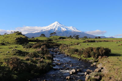 Scenic view of snowcapped mountains against blue sky
