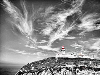 Lighthouse by sea against sky