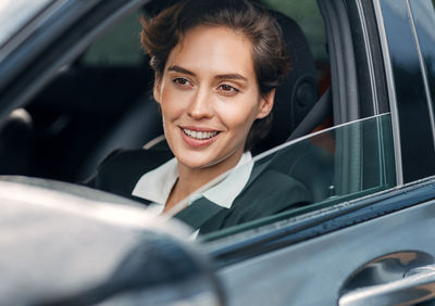 Portrait of a smiling young woman in car