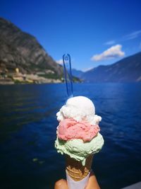 Person holding ice cream cone in lake